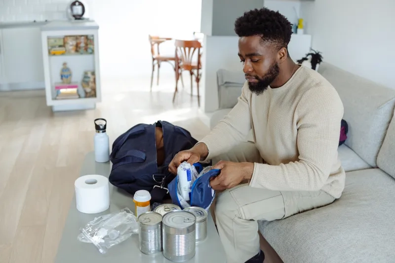 Man organizing emergency kit on a table in a living room