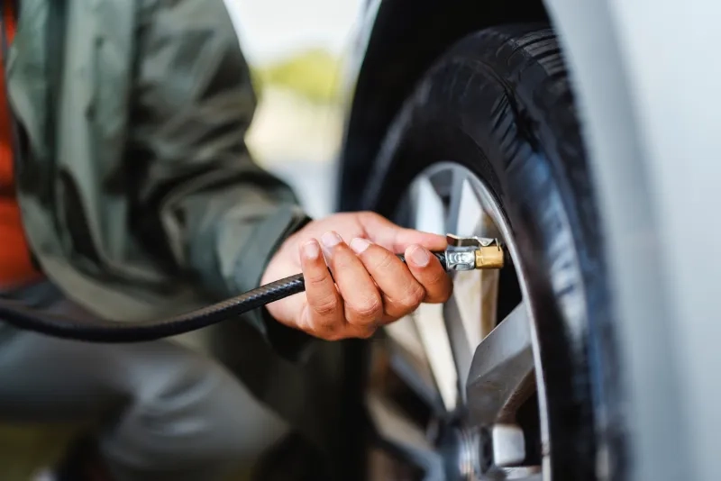 Shows a person inflating a car tire