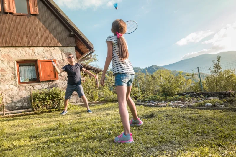 Father and daughter playing badminton in the countryside