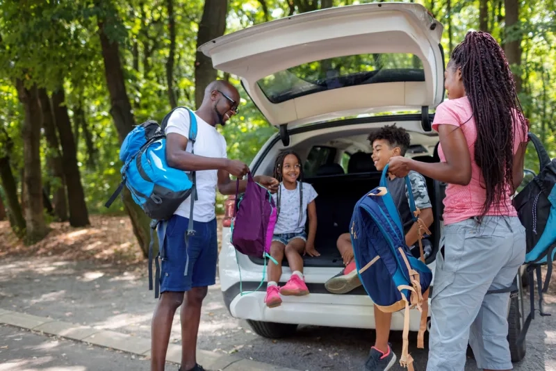 Family getting next to car with open trunk