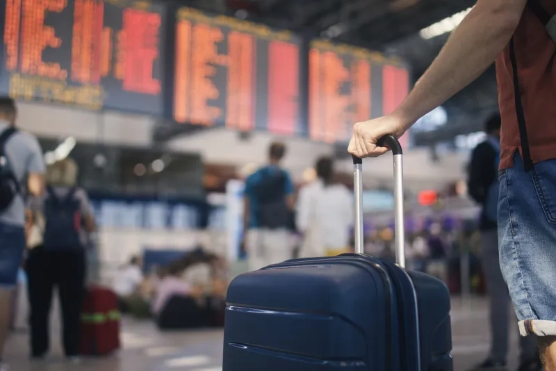 Man holding suitcase at airport