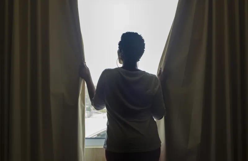 Woman closing curtains