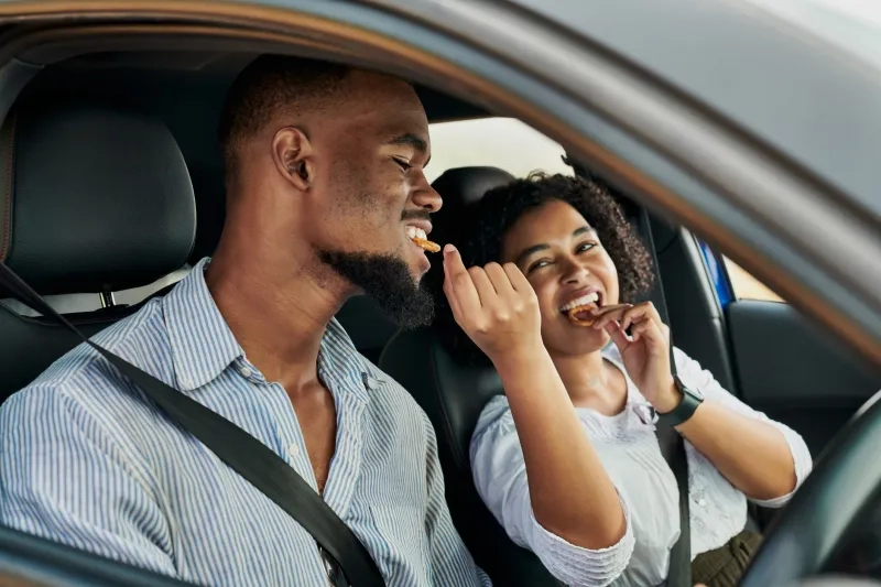 couple eatting snacks in the car