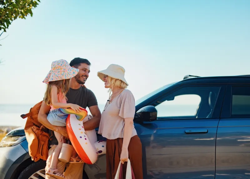 Family next to car getting ready for a day at the beach