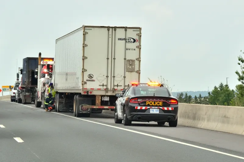 Police car stopped on the side of the highway.