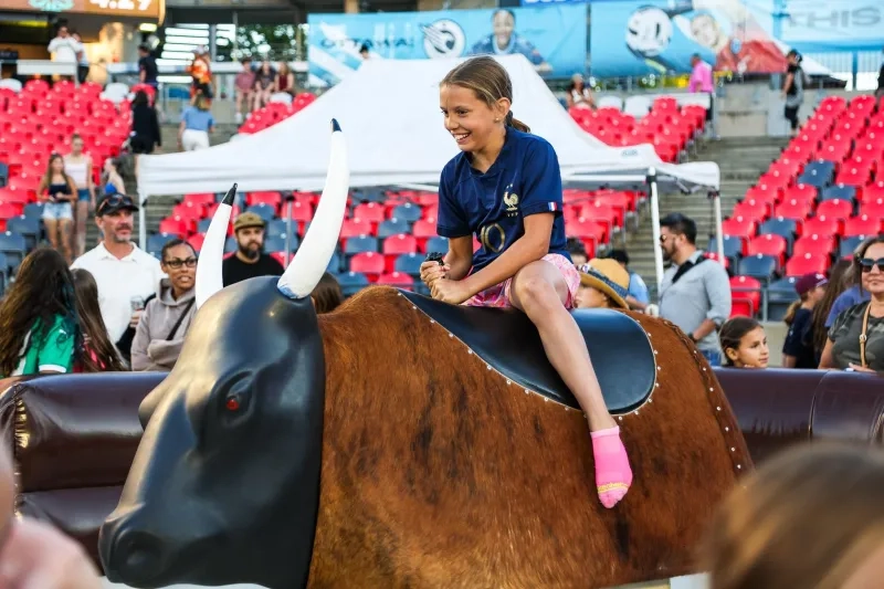Girl ridding a mechanical bull at Ottawa Rapid FC game