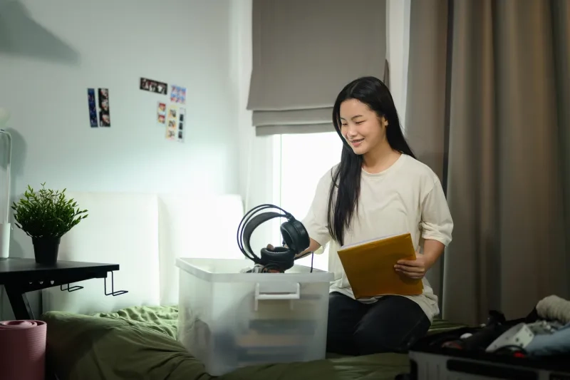 female student packs headphones
