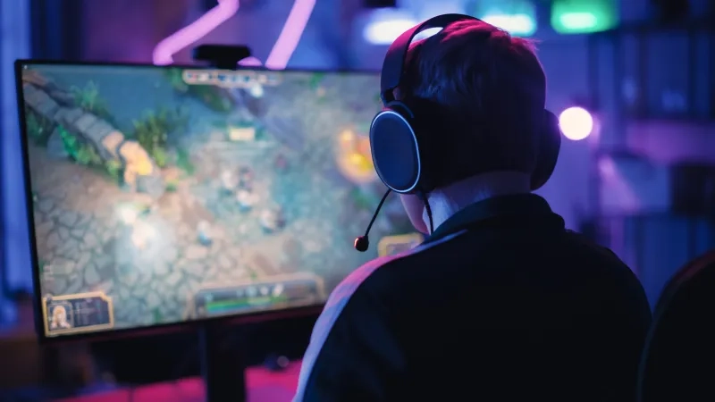 Over the Shoulder Angle of a Young Female Gamer Winning in a Video Game on Personal Computer