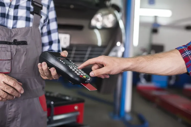 Customer paying with credit card machine payment at car service