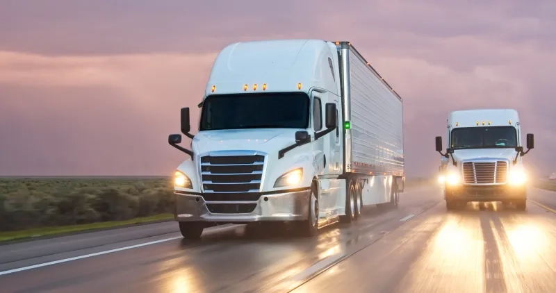 A semi-truck driving south on Interstate 5 in the Central Valley on a stormy evening.