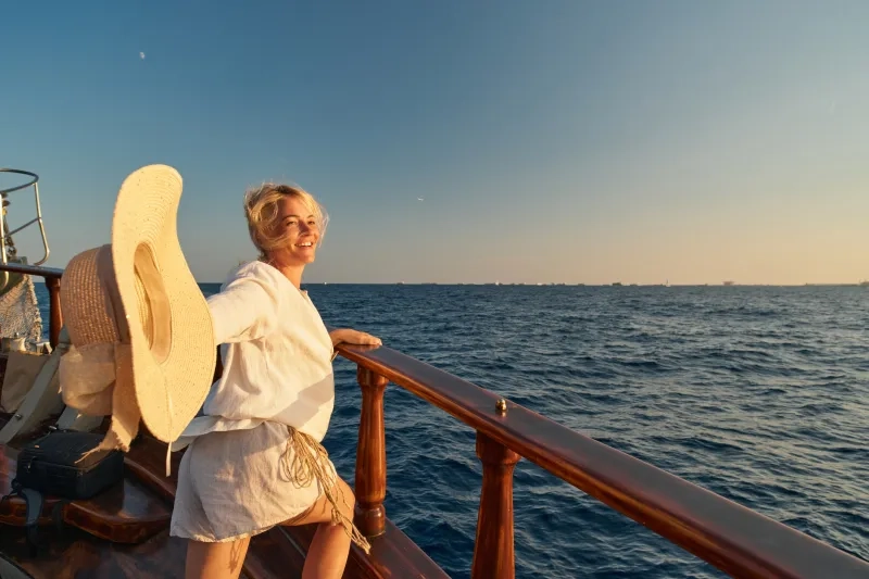 Woman on exterior deck of cruise ship looking at water