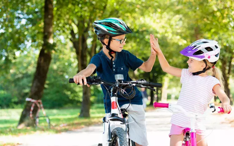 Children bicycling high five