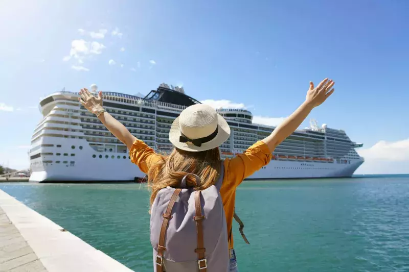 Back view of traveler girl with raised arms standing in front of