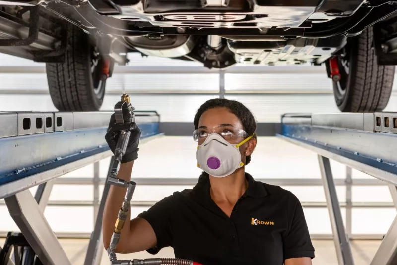 Female Technician Broadspraying Underside