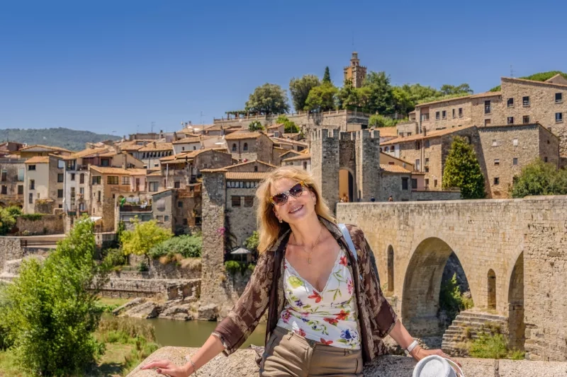 A happy woman against the background of the ancient Spanish city of Besalú