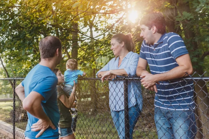 Neighbors talking between fences