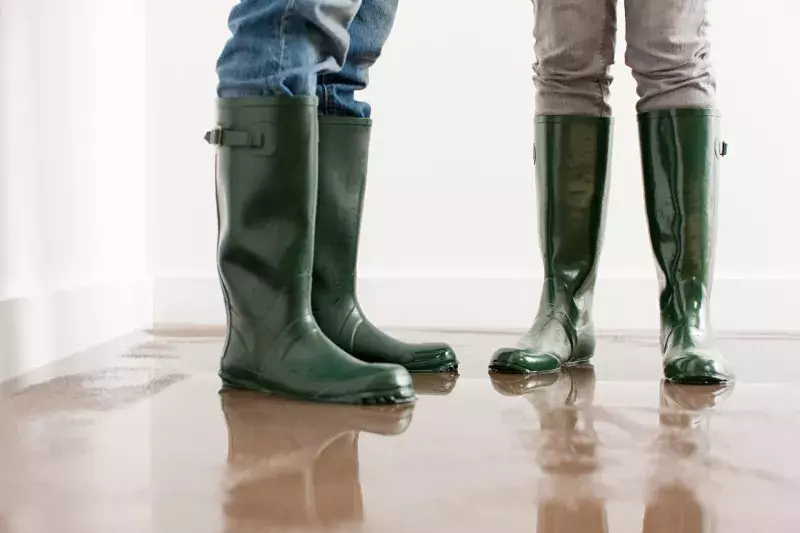 Young couple in wellington boots on flooded floor