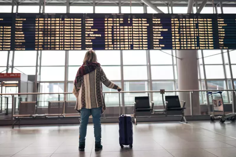 Woman reading departure board on airport