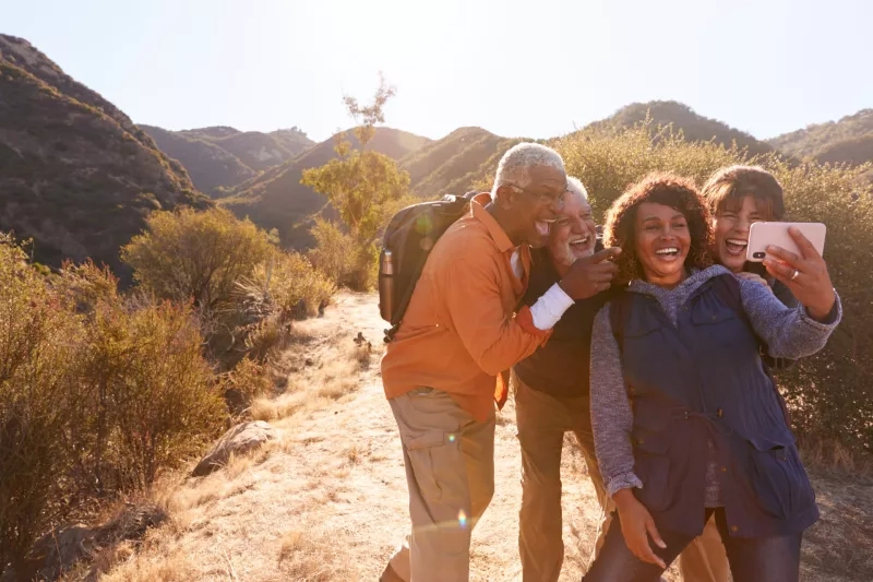 Group Of Senior Friends Posing For Selfie As They Hike Along Trail In Countryside Together