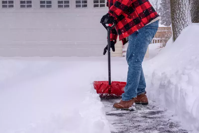 Man shoveling heavy snow in the driveway