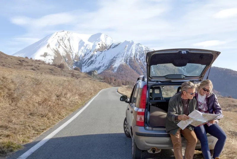 Couple pauses along mountain road to check direction