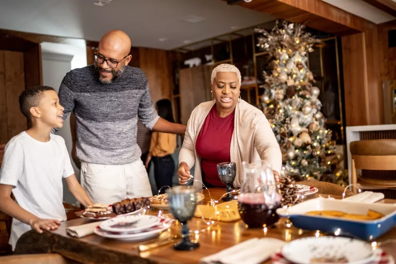 Family setting the table for Christmas lunch or dinner at home