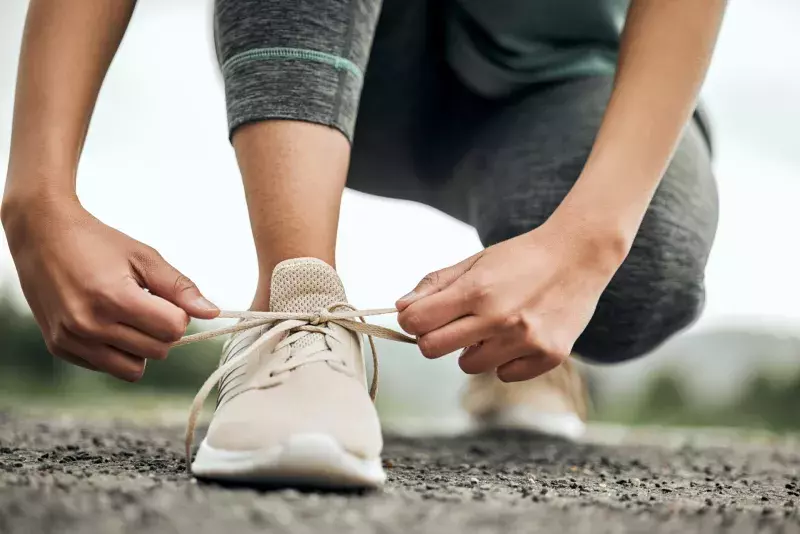 Shot of an unrecognizable person tying their shoelaces before a run