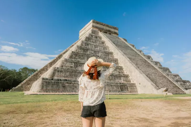 Woman on the background of Chichen Itza pyramid in Mexico