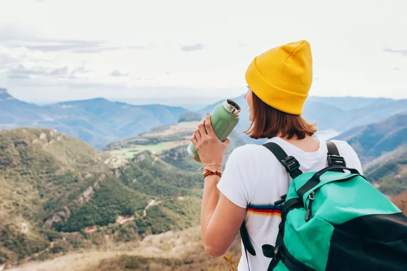 Drinking hiking woman with bottle of water and backpack