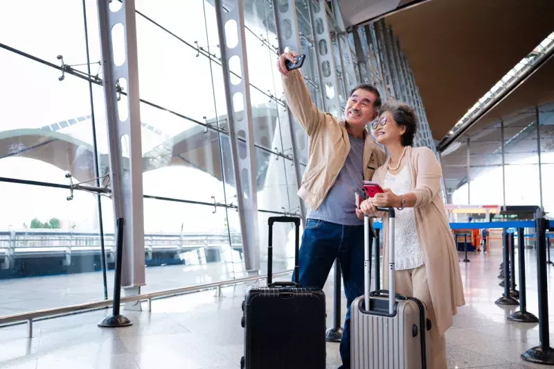 seniors taking selfie at the airport terminal