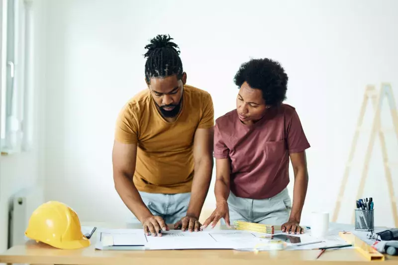 couple examining blueprints during home renovation process.