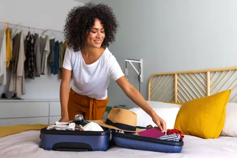 young woman packing suitcase at home. Preparing for summer holidays abroad.