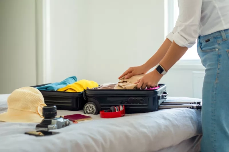 Woman preparing suitcase for holidays