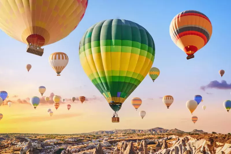 Landscape of fabulous Kapadokya. Colorful flying air balloons in sky at sunrise in Anatolia. Vacations in beautiful destination in Goreme, Turkey