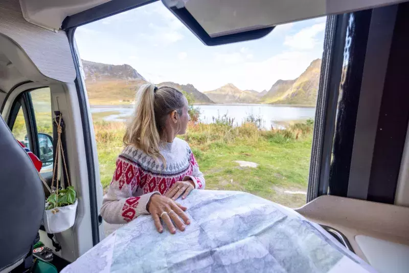 RV Road trip- woman in a camper van looking at road map