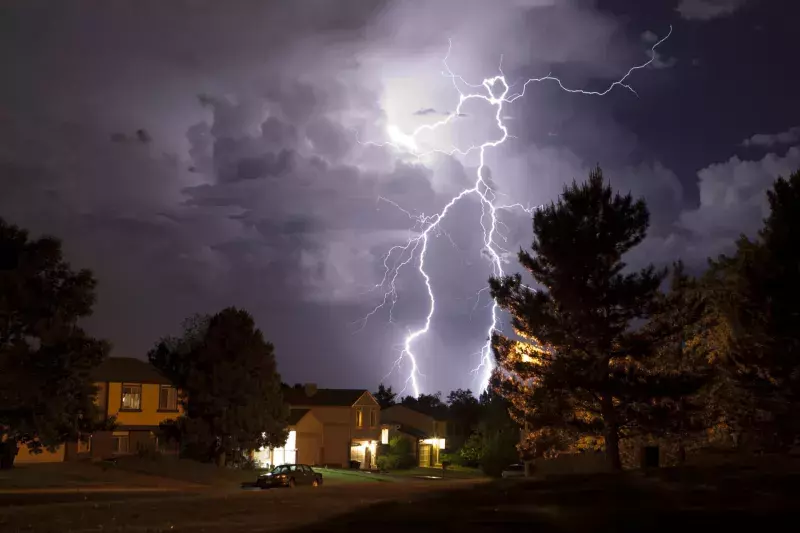 Lightning bolt and thunderhead storms over Denver neighborhood homes