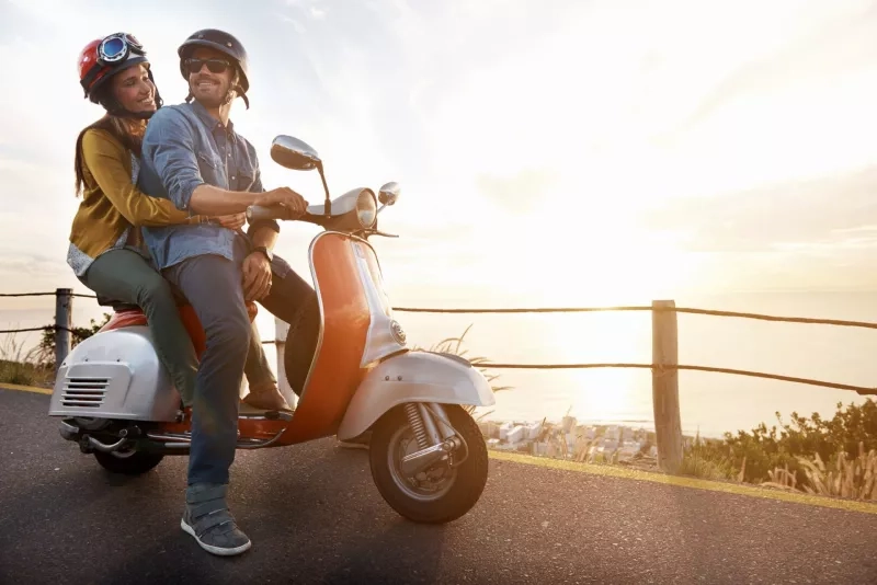 A young couple rides an electric scooter