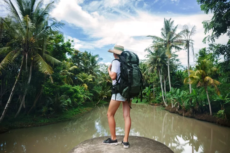 Woman standing on the edge near tropical river